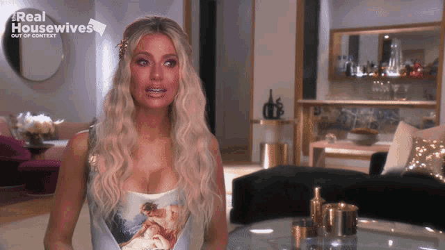 a woman is standing in a living room with the words real housewives out of context above her