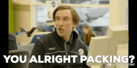 a man in a tesco uniform is sitting at a desk and talking to someone .