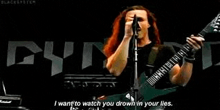 a man is playing a guitar and singing into a microphone while standing on a stage .