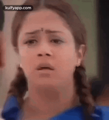 a close up of a woman 's face with a shocked look on her face .