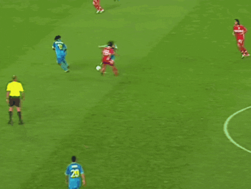 a soccer goalie dives to block a shot in front of a heineken sign