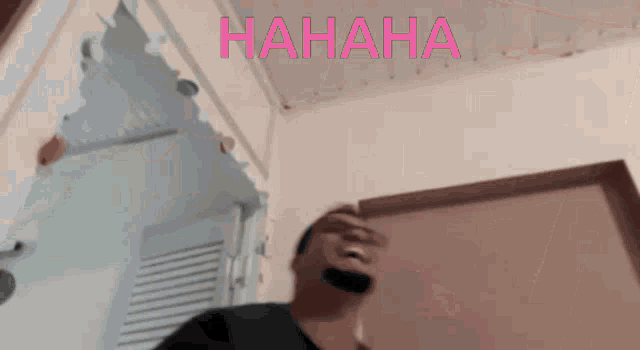 a man is laughing in front of a wall that says hahaha