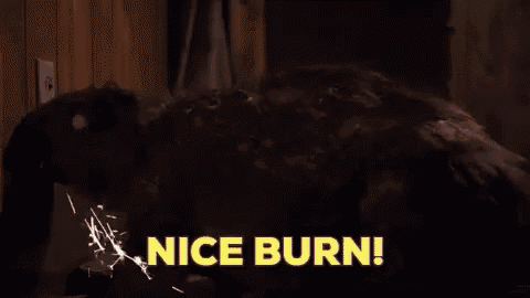 a man is standing in front of a wall with smoke coming out of it and the words `` nice burn '' .