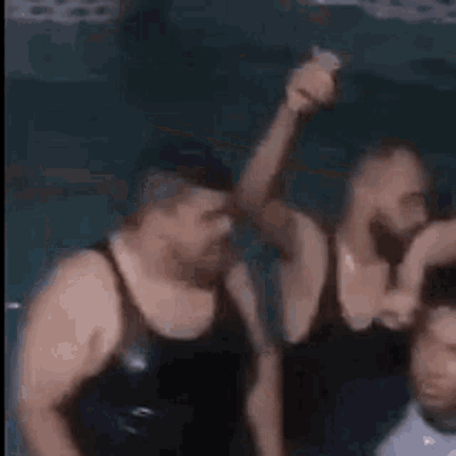 three men are dancing together in a dark room .
