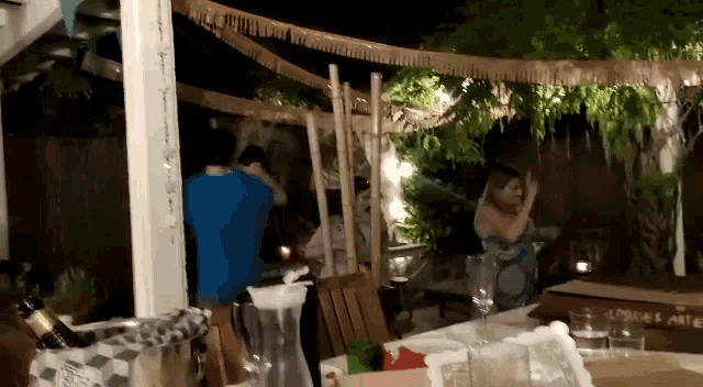 a group of people are sitting at a table in a backyard .