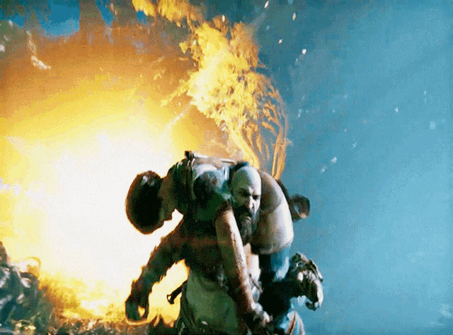 a man with a beard is carrying another man in front of a fire