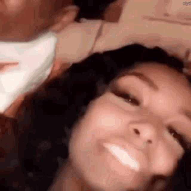 a woman wearing a mask is smiling for the camera while a man kisses her .