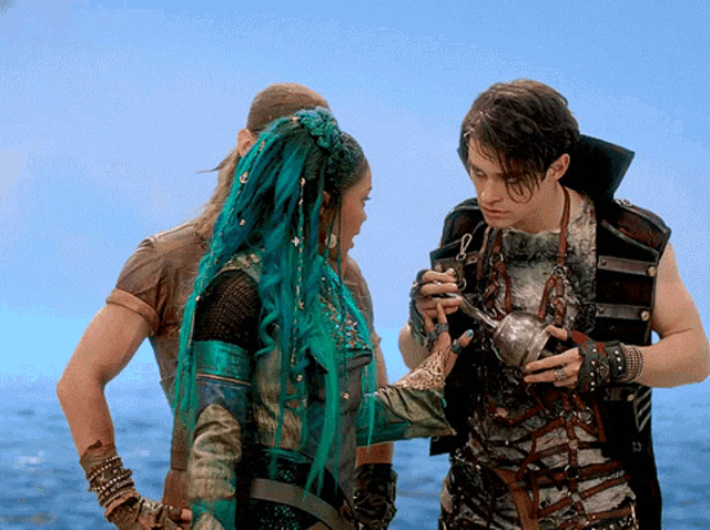 a man is holding a teapot while standing next to a woman with green hair