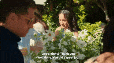 a woman stands in front of a bouquet of white flowers and says good right thank you well done you did a great job .