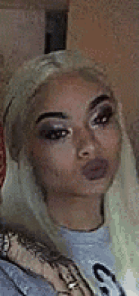 a close up of a woman 's face with a lot of makeup on her face .