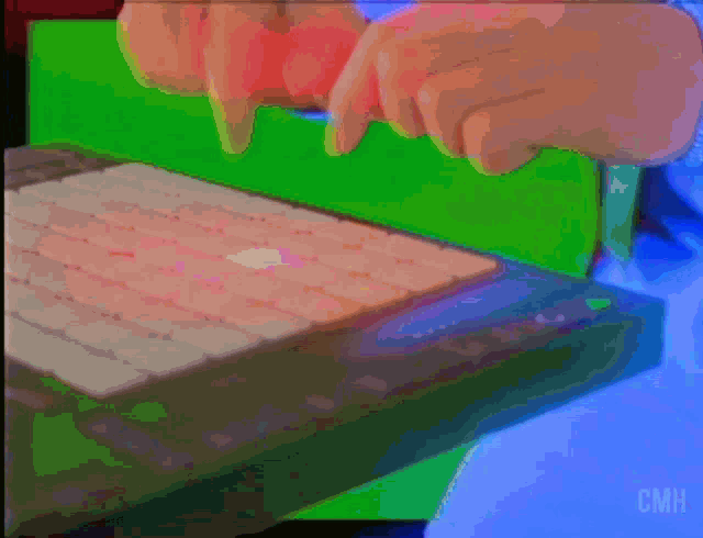 a person is typing on a keyboard with a green screen behind them and the letters cmh are visible