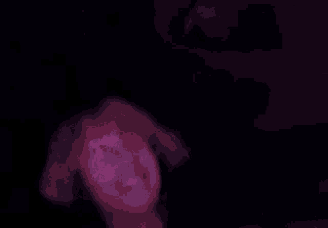 a close up of a person 's face with their hands in the air in a dark room .