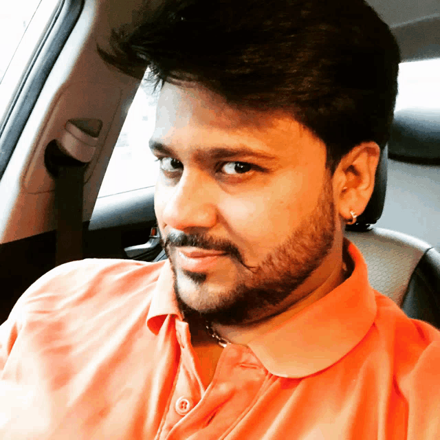 a man with a beard wearing an orange shirt