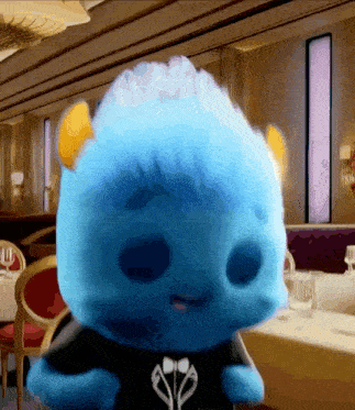 a blue stuffed animal is wearing a black shirt with earbuds on it