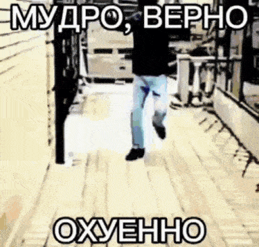 a man is walking down a wooden walkway with a russian text .