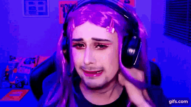 a man wearing a purple wig and headphones is making a sad face .