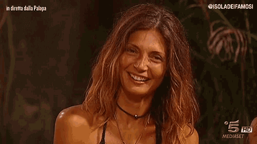 a woman is smiling in front of a screen that says in diretta dalla palapa on it