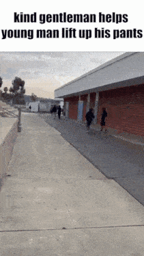 a gentleman helps a young man lift up his pants while walking down a sidewalk .