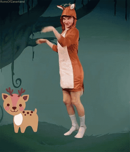 a person in a deer costume is dancing next to a deer