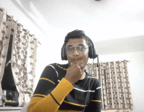 a man wearing glasses and headphones is sitting in front of a window