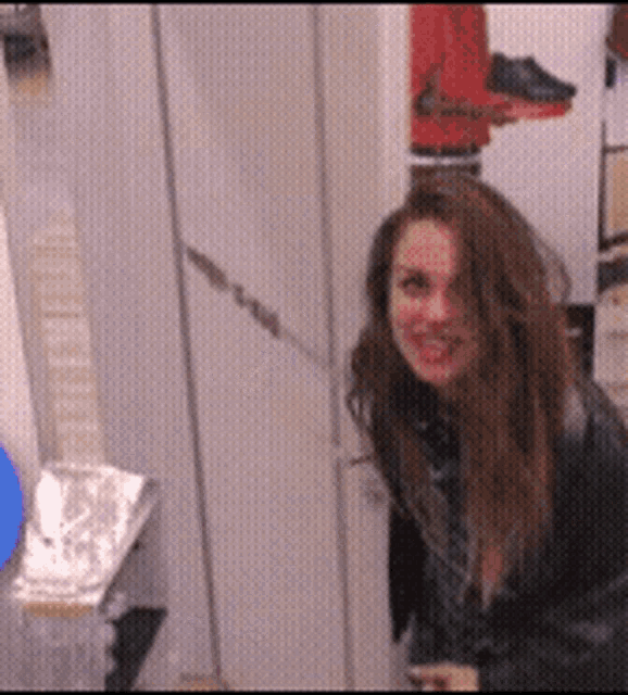 a woman in a black jacket is standing in a room