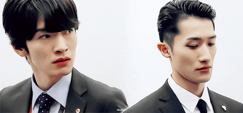 a man in a suit and tie is standing next to another man in a suit