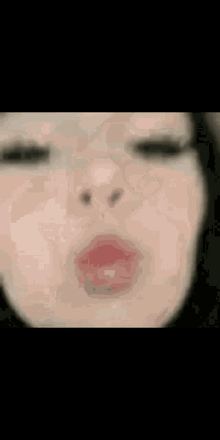 a close up of a woman 's face with her eyes closed and a smile on her face .