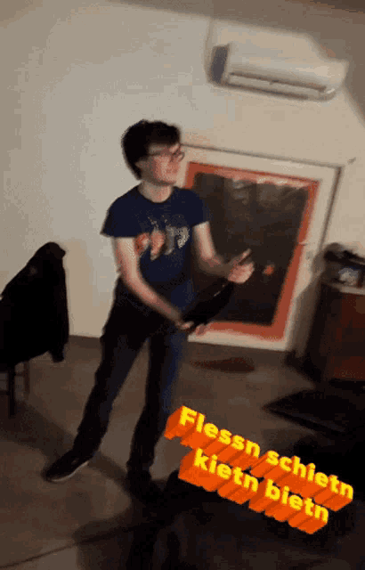 a man in a blue shirt is dancing in a room with the words flessn schietn kieth bieln