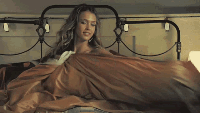 a woman is laying on a bed with a lamp and a lampshade
