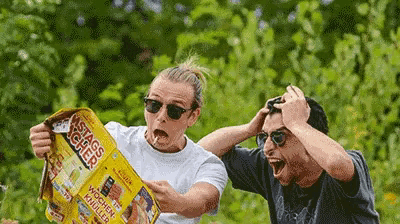 two men are looking at a newspaper that says ' wochen ' on it