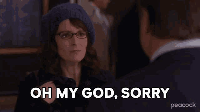 a woman wearing glasses and a blue hat says " oh my god sorry "