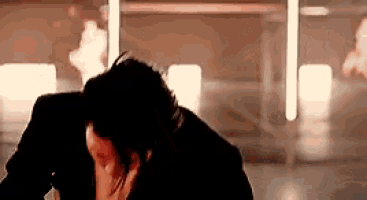 a man and woman are kissing in front of a fire .