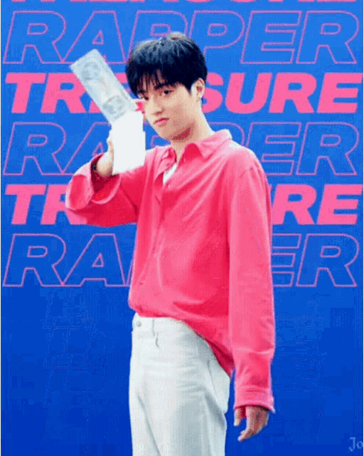 a young man in a pink shirt is holding a trophy in front of a blue background that says rapper