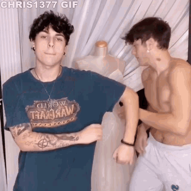 two shirtless men are standing next to each other in front of a mannequin in a room .