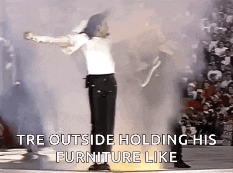 a man in a white shirt and black pants is standing on a stage with his arms outstretched and holding his furniture like .