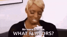 a woman is sitting on a couch drinking a cup of tea and asking what flavors .