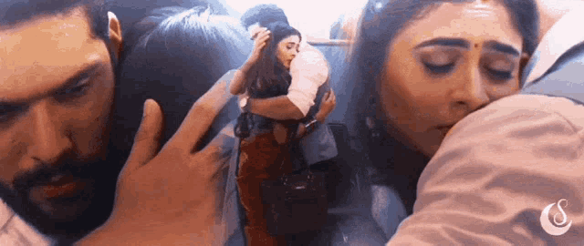 a man is touching a woman 's forehead while a woman looks on ..