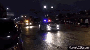 a police car driving down a street at night
