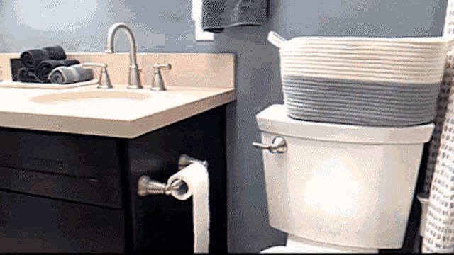 a bathroom with a sink toilet and a basket on top of the toilet