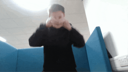 a blurry picture of a man standing in front of a blue divider