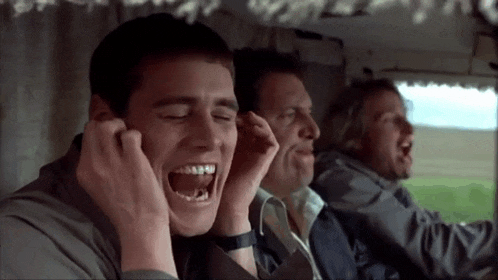 a man is covering his ears with his hands while laughing