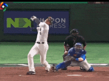 a baseball player swings his bat in front of a sign that says next on it