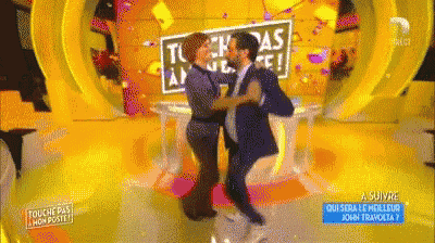 a man and a woman are dancing in front of a sign that says touche pas mon poste