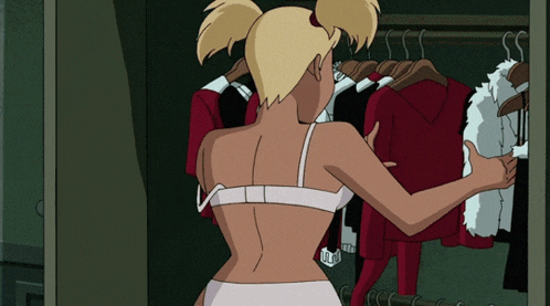 a woman in a bra is standing in a closet with clothes hanging