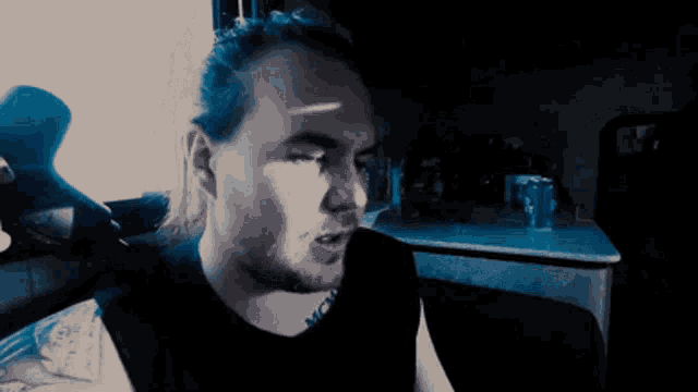 a man with long hair and a tattoo on his arm is talking