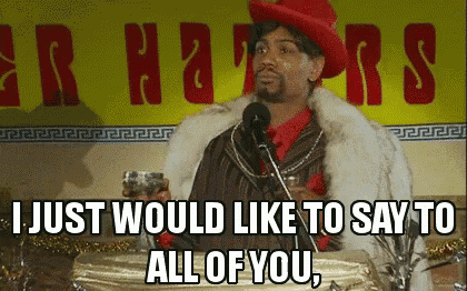 a man in a fur coat is giving a speech in front of a yellow sign that says haters