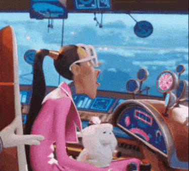 a woman in a pink suit is sitting in the cockpit of an airplane .