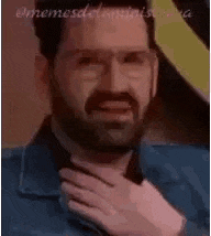 a man with a beard and glasses is making a funny face while holding his hands to his chest .
