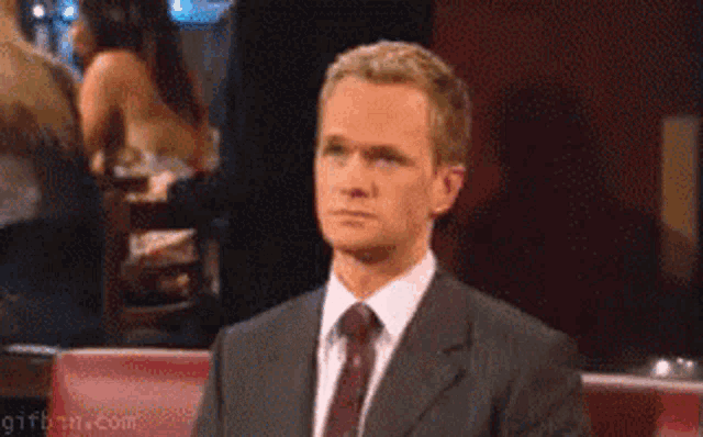 a man in a suit and tie sitting in a chair