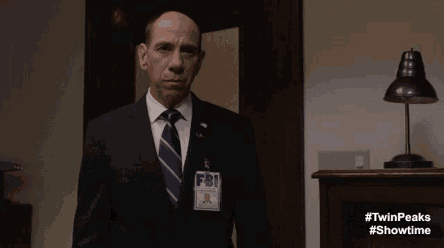 a man wearing a fbi badge says please